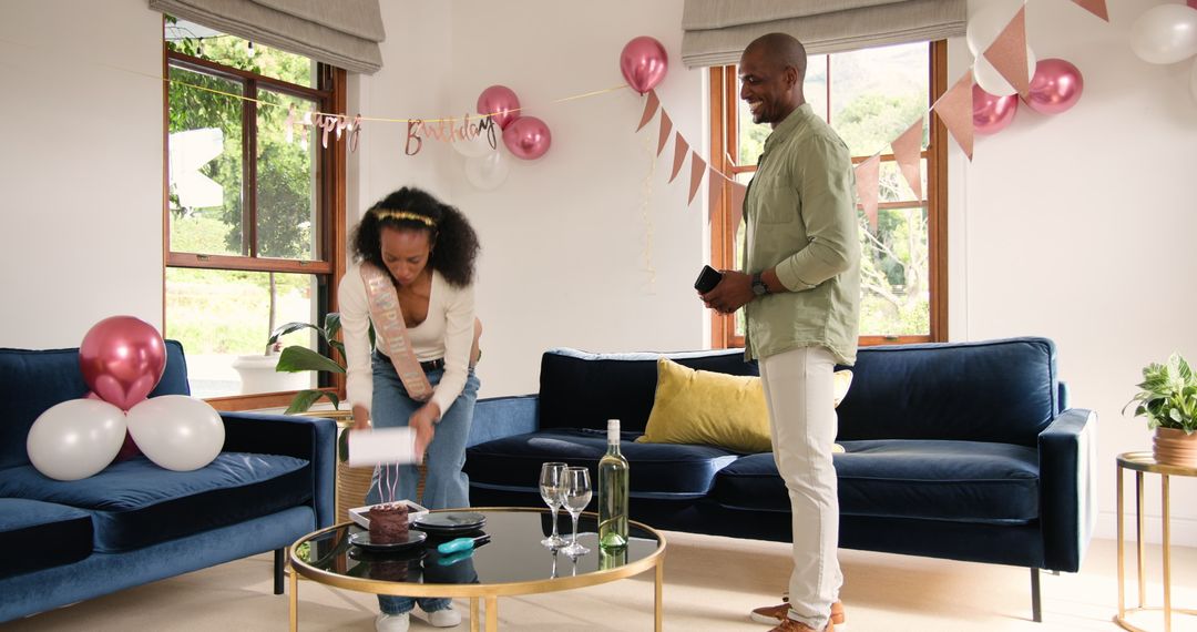 Diverse Couple Setting Up Home Birthday Party with Cake and Decor