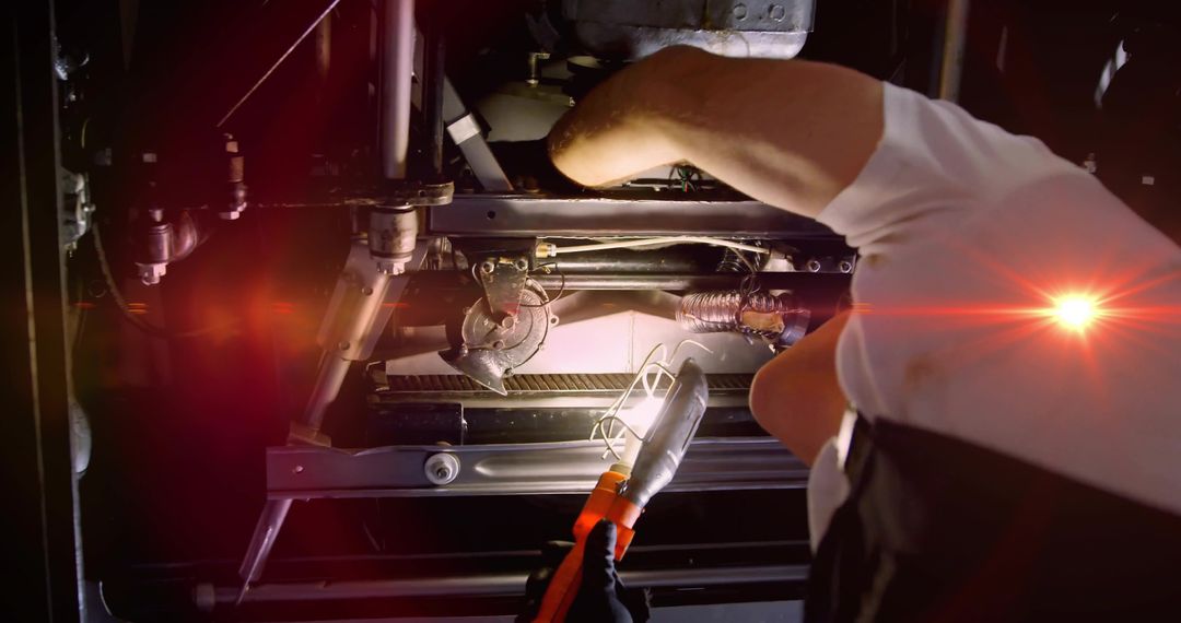 Mechanic Inspecting Vehicle Undercarriage with Caged Work Lamp and Safety Gloves