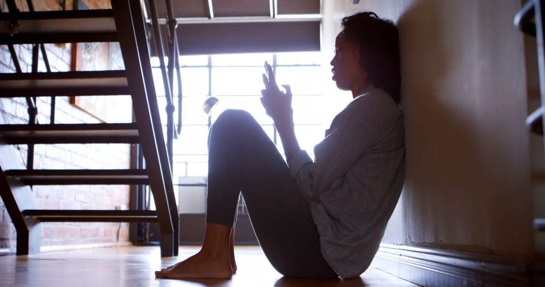 Woman using mobile phone while sitting on the floor at home 4k - Free Images, Stock Photos and Pictures on Pikwizard.com