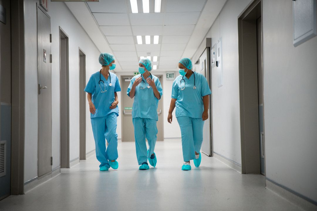 Healthcare Professionals Walking in Hospital Corridor - Free Images, Stock Photos and Pictures on Pikwizard.com