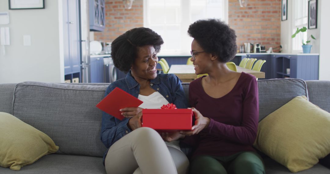 Happy African American Mother Receives Gift from Daughter at Home - Free Images, Stock Photos and Pictures on Pikwizard.com