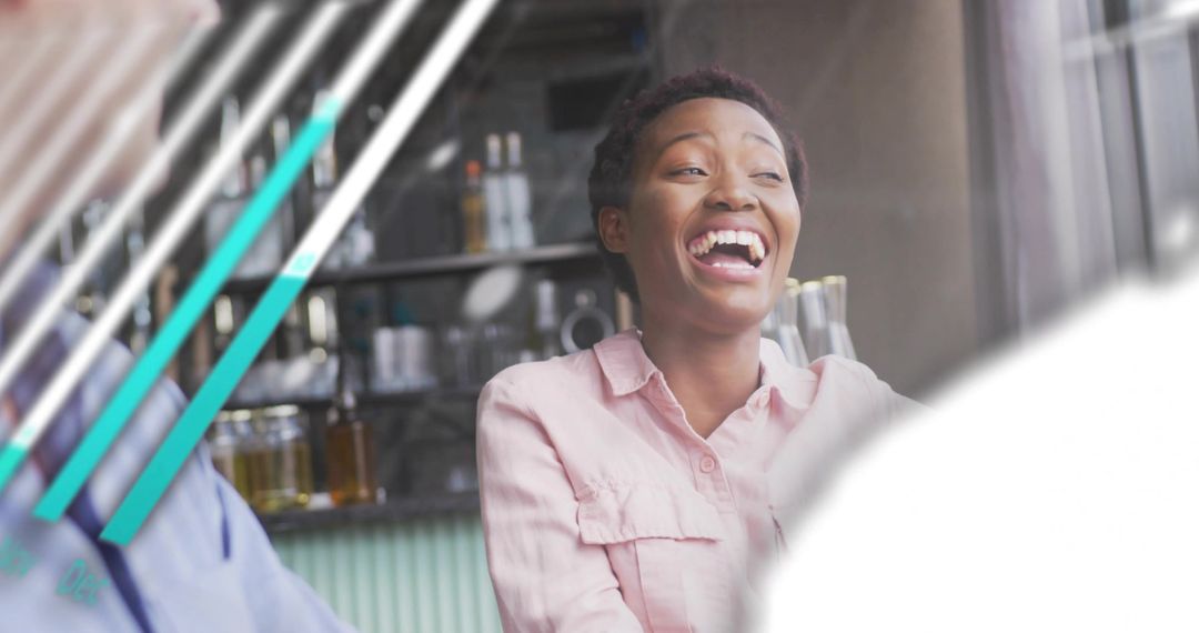 Laughing woman sharing lively conversation at cafe counter with coffee bar background
