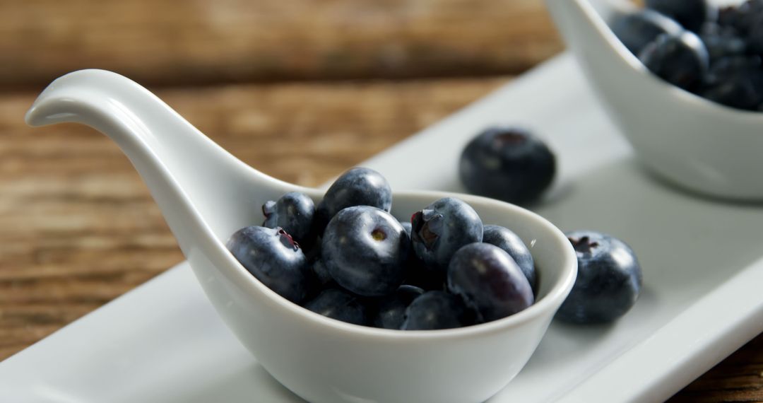 Fresh Blueberries in White Ceramic Spoons on Rustic Wooden Table - Free Images, Stock Photos and Pictures on Pikwizard.com