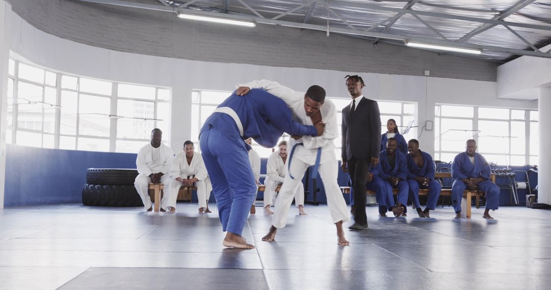 Martial Arts Training in Dojo with Audience in Background