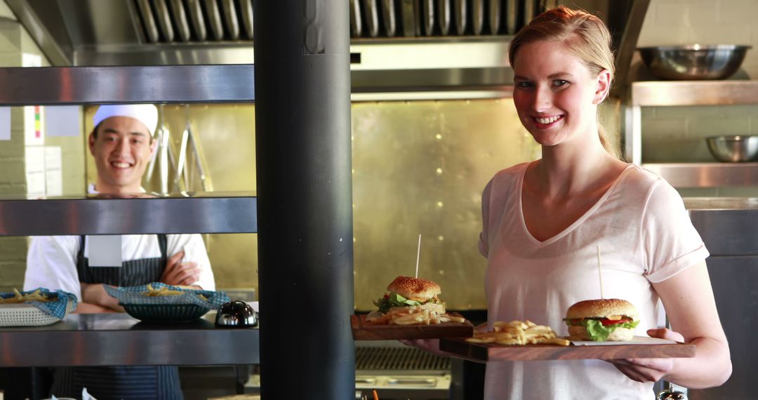 Smiling Waitress Serving Burgers in Busy Restaurant - Free Images, Stock Photos and Pictures on Pikwizard.com