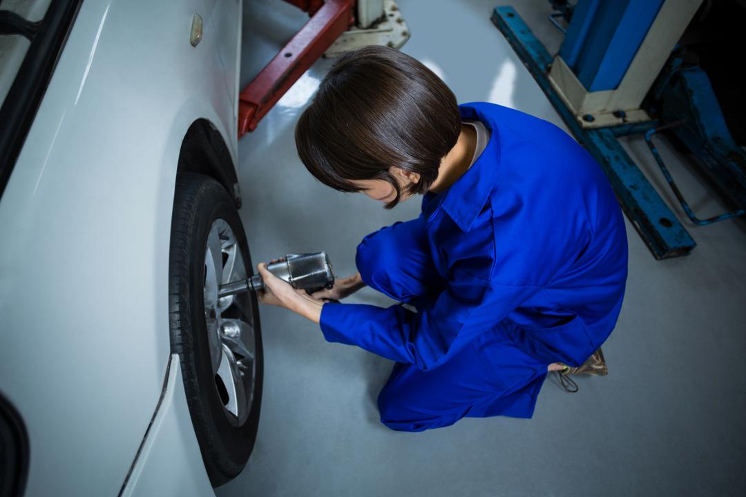 Female Mechanic Using Pneumatic Wrench on Car Wheel in Repair Garage - Free Images, Stock Photos and Pictures on Pikwizard.com