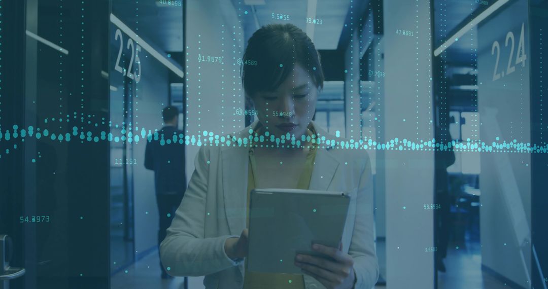 Businesswoman Analyzing Data on Tablet in Corporate Hallway