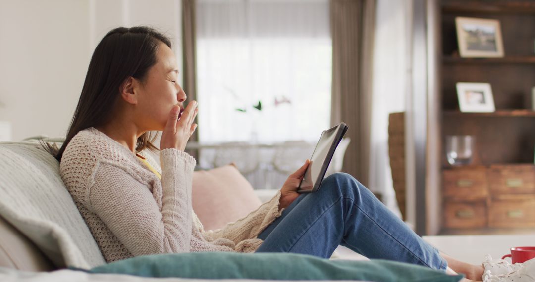 Image of happy asian woman resting on sofa with tablet - Free Images, Stock Photos and Pictures on Pikwizard.com