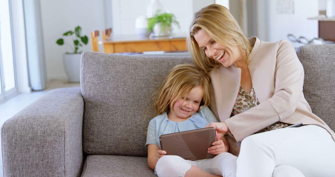 Mother and Daughter Using Tablet Together on Couch - Free Images, Stock Photos and Pictures on Pikwizard.com