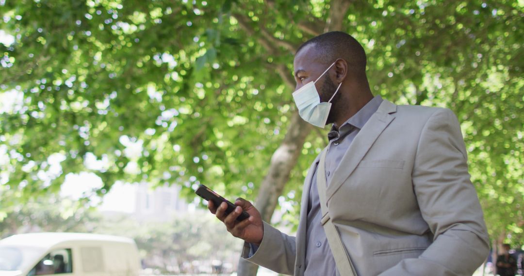 Businessman with Mask Using Smartphone in Urban Setting