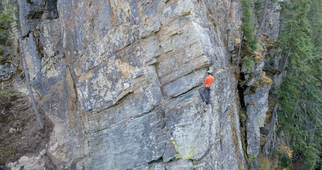 Caucasian man scales a steep cliff in the wilderness - Free Images, Stock Photos and Pictures on Pikwizard.com
