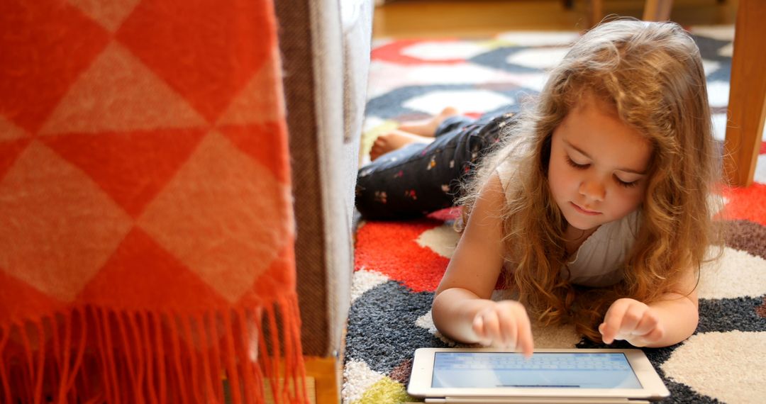 Little Girl Using Tablet on Floor at Home - Free Images, Stock Photos and Pictures on Pikwizard.com