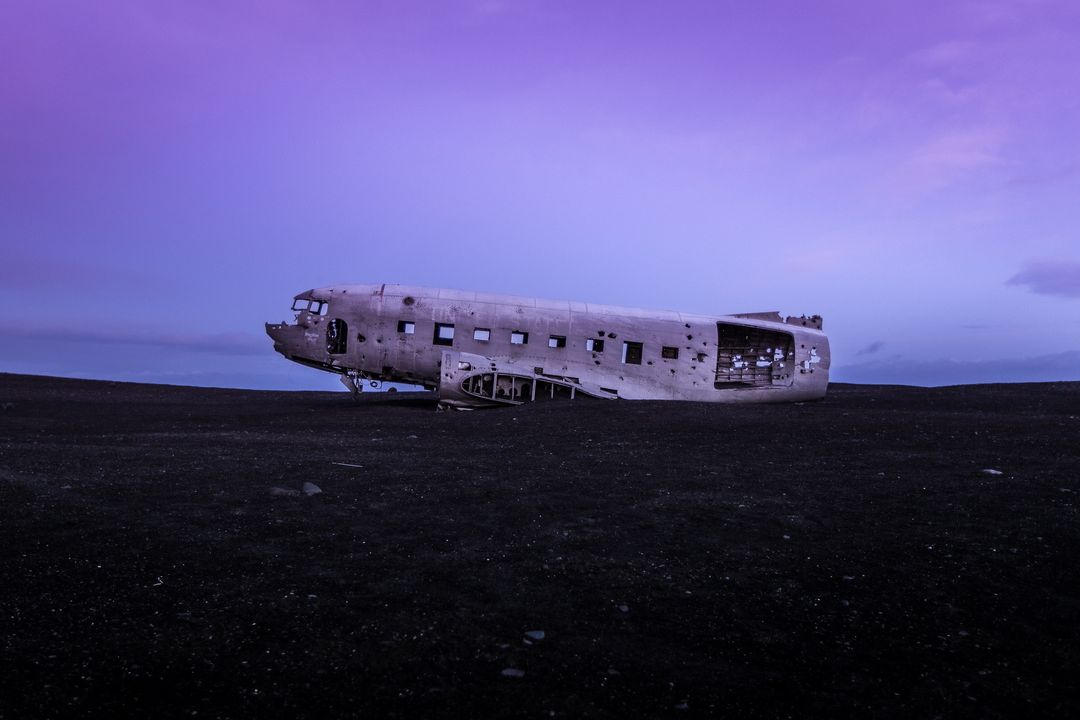 Abandoned plane crash wreckage on solitary beach at twilight