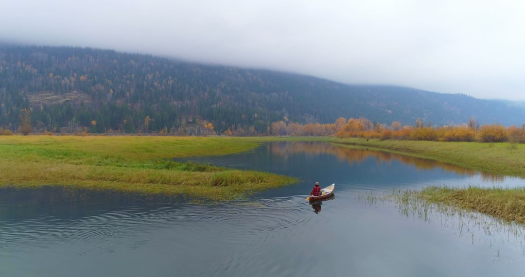 Solitary Person Canoeing on Calm Autumn Lake - Free Images, Stock Photos and Pictures on Pikwizard.com