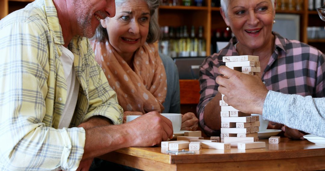 Group of Seniors Playing a Block Stacking Game at a Cafe - Free Images, Stock Photos and Pictures on Pikwizard.com