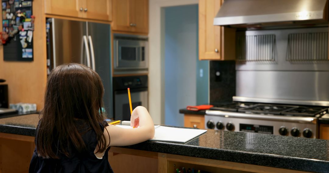 Child Studying at Kitchen Counter in Modern Home - Free Images, Stock Photos and Pictures on Pikwizard.com