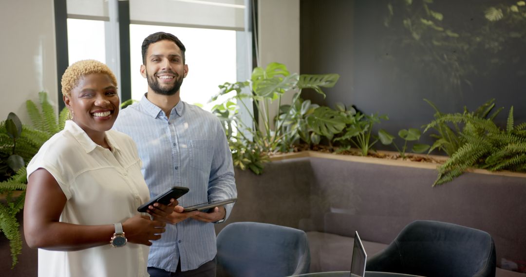 Smiling Colleagues with Tablets in Modern Office with Indoor Plants