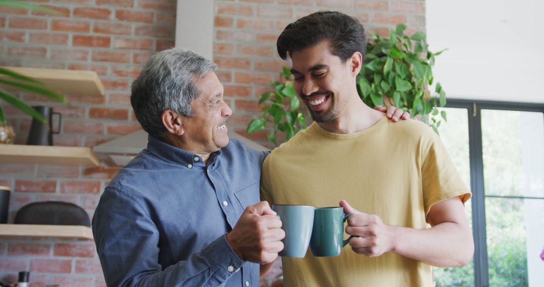 Loving father and son enjoying cups of coffee in kitchen - Free Images, Stock Photos and Pictures on Pikwizard.com