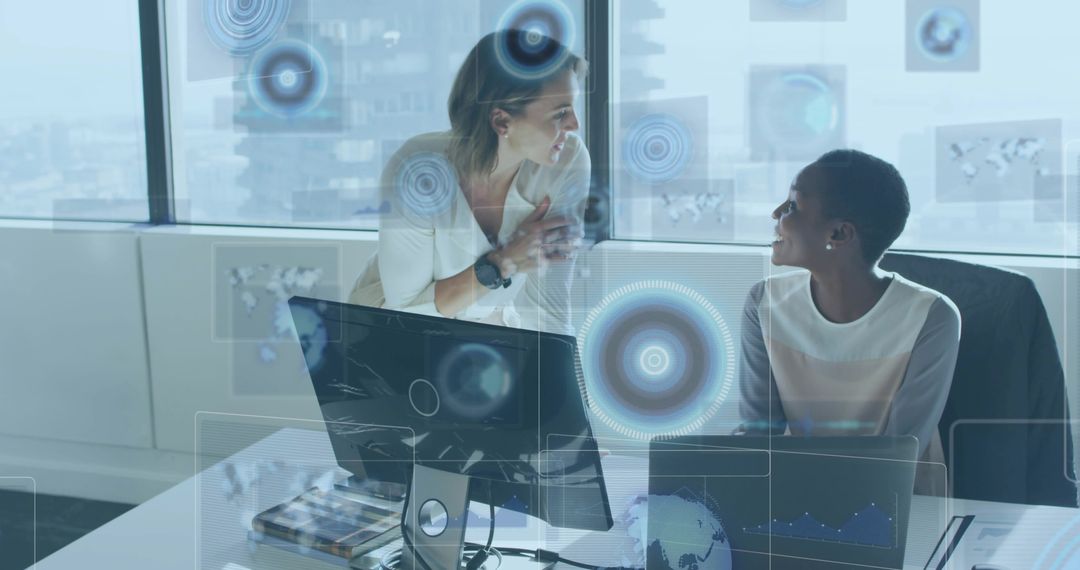 White and Black women collaborating with augmented reality data visuals in high-rise office