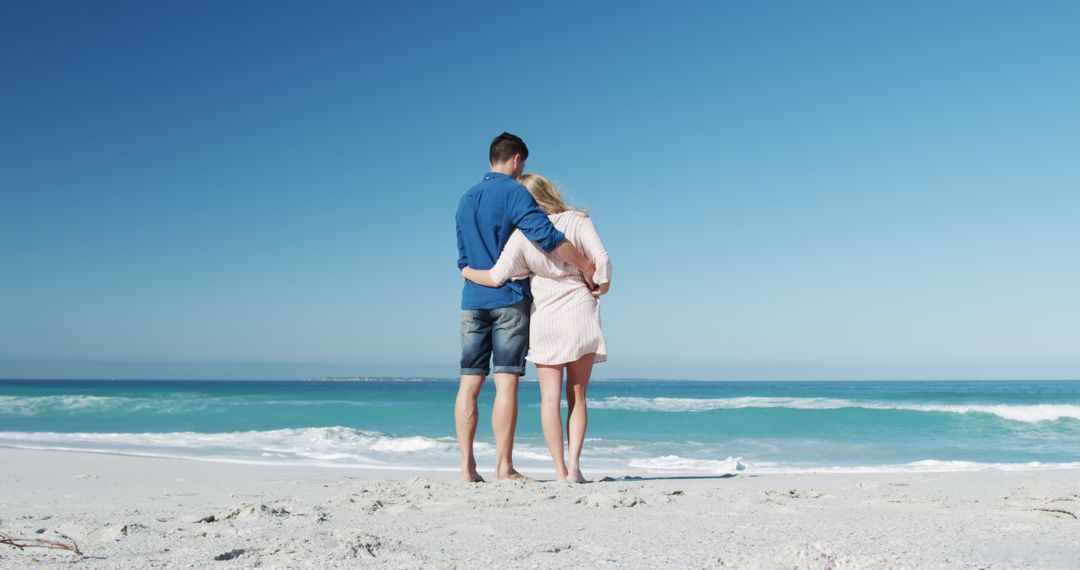 Romantic couple admiring ocean view on sunny beach - Free Images, Stock Photos and Pictures on Pikwizard.com