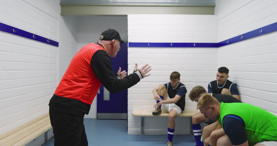 Soccer Coach Instructing Players in Locker Room Discussing Tactics