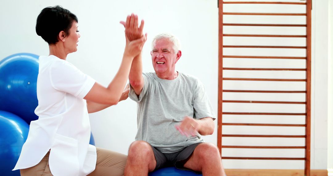 Cheerful Physiotherapist Assisting Senior's Arm Stretching