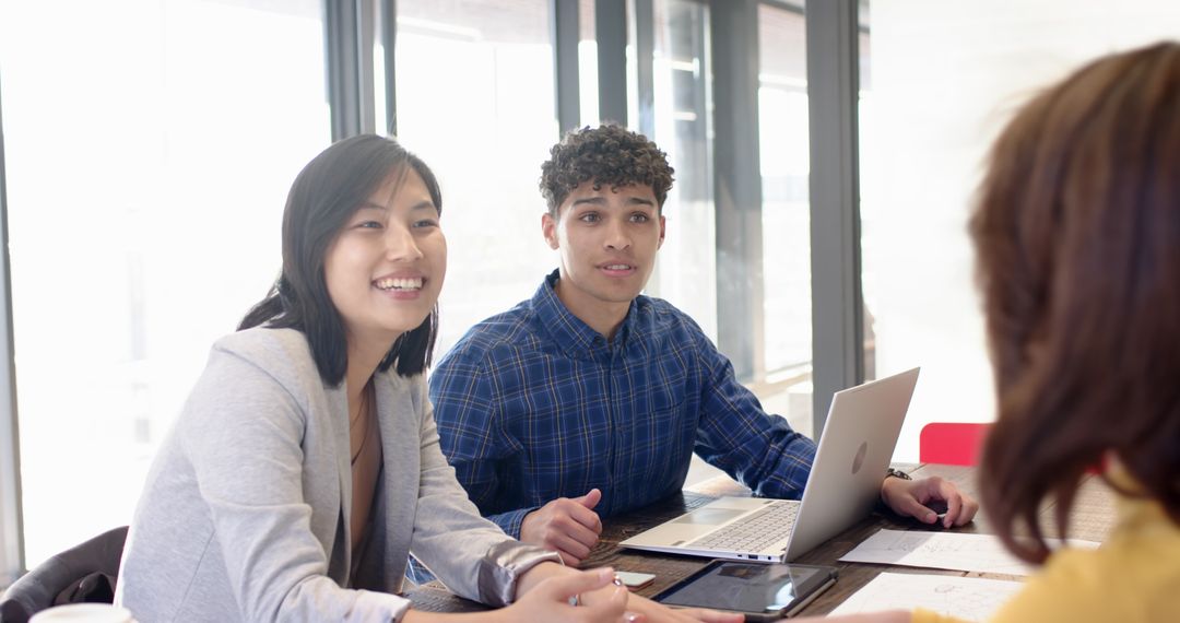 Team Meeting with Laptop and Documents in Modern Office