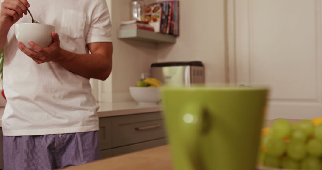 Man Enjoying Breakfast Cereal in Cozy Home Kitchen - Free Images, Stock Photos and Pictures on Pikwizard.com