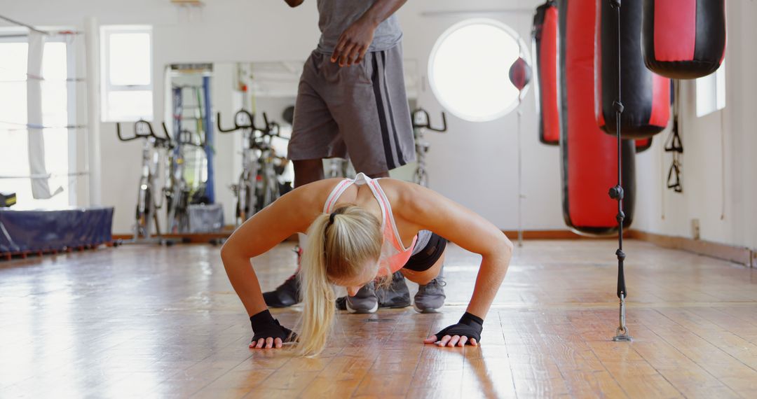 Female Athlete Doing Push-Ups in Gym with Coach - Free Images, Stock Photos and Pictures on Pikwizard.com