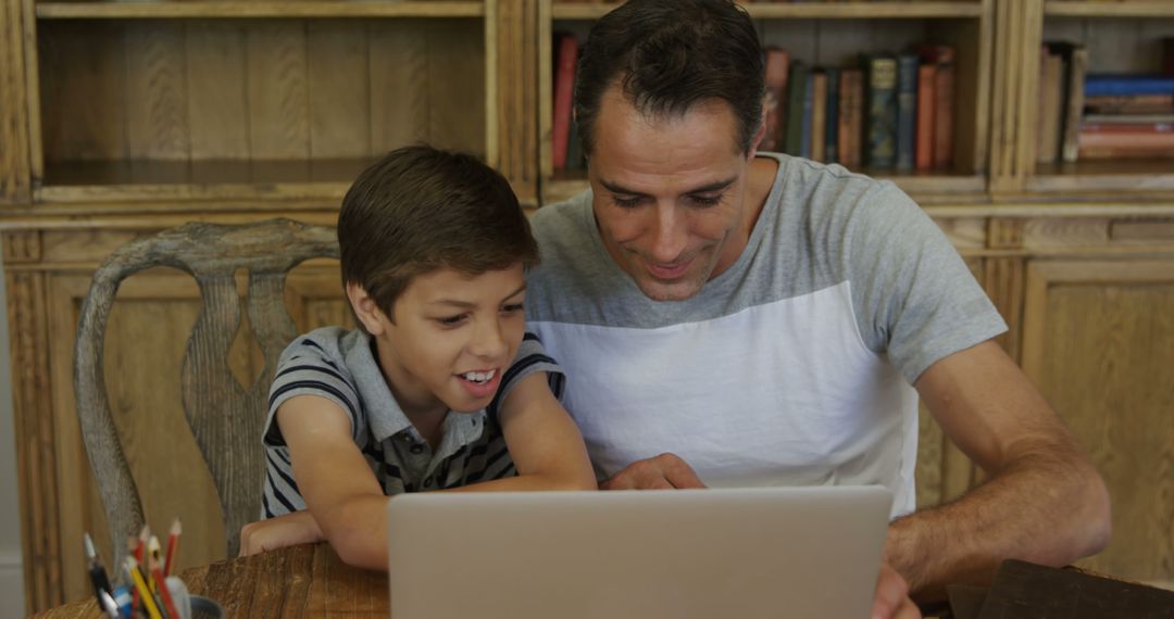 Father and Son Bonding Over Laptop at Home - Free Images, Stock Photos and Pictures on Pikwizard.com