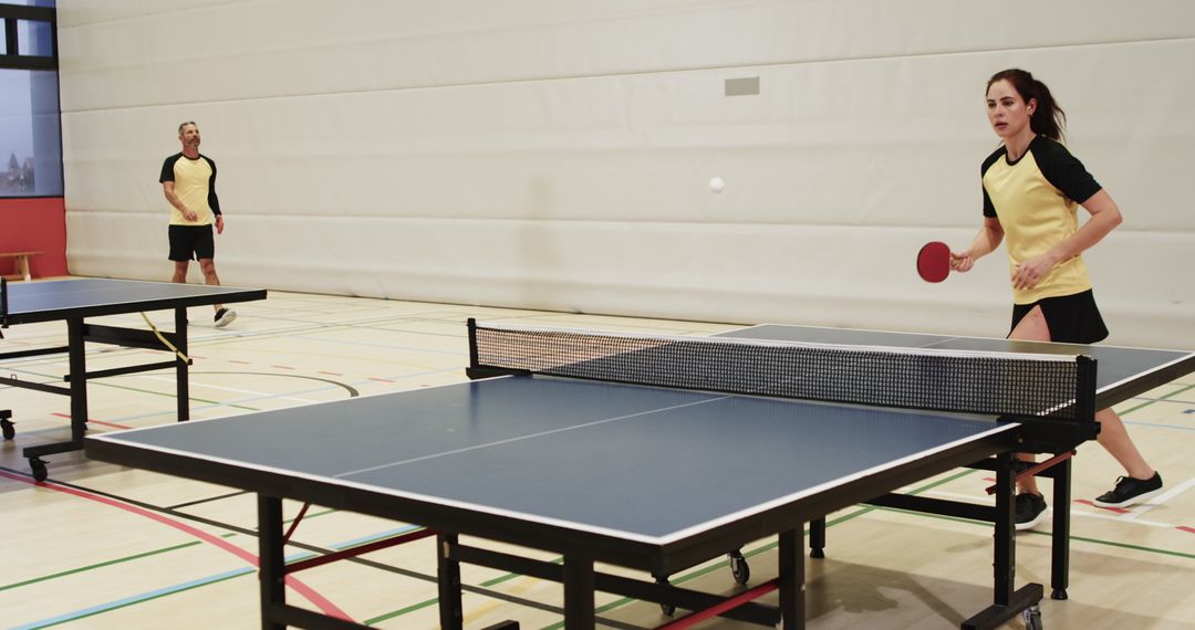 Dynamic Mixed Doubles Table Tennis Match in Gym