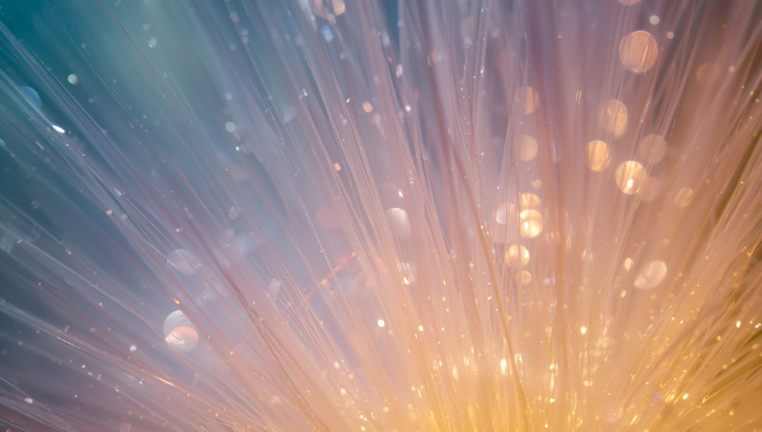 Glowing Fiber Optic Strands Radiating Warm Golden Rays into Teal Bokeh Gradient