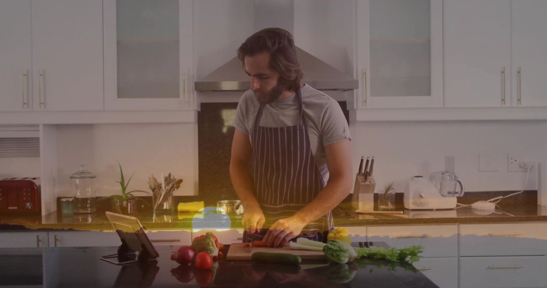 Man Chopping Vegetables in Modern Kitchen with Tablet