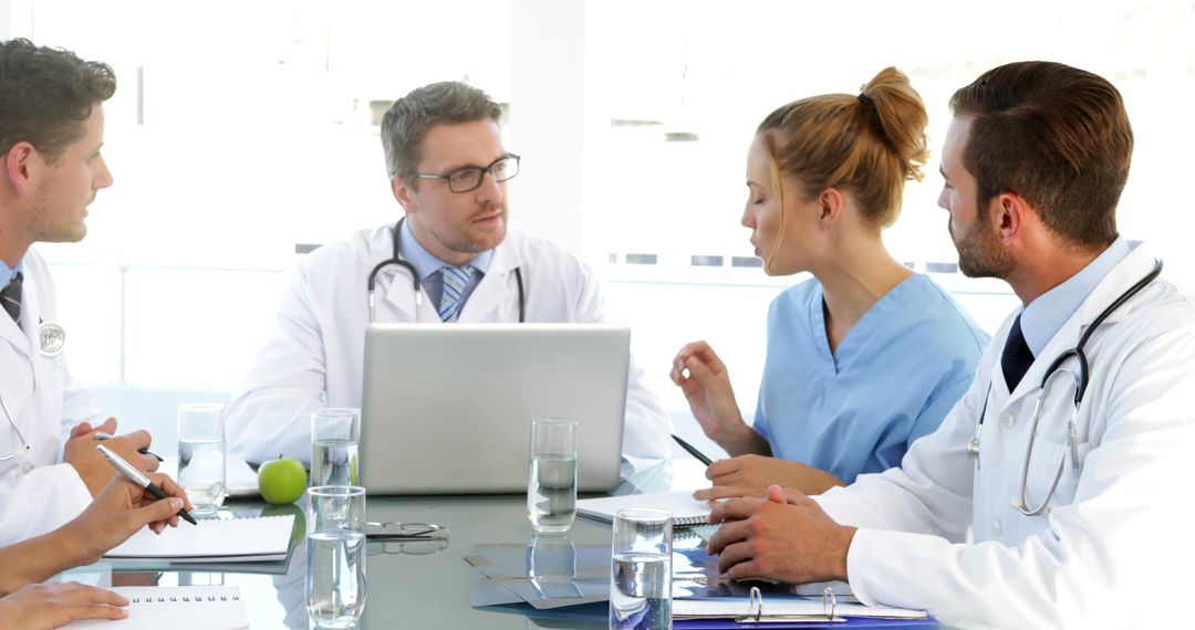 Medical Team in Discussion Around Table in Modern Hospital Setting - Free Images, Stock Photos and Pictures on Pikwizard.com