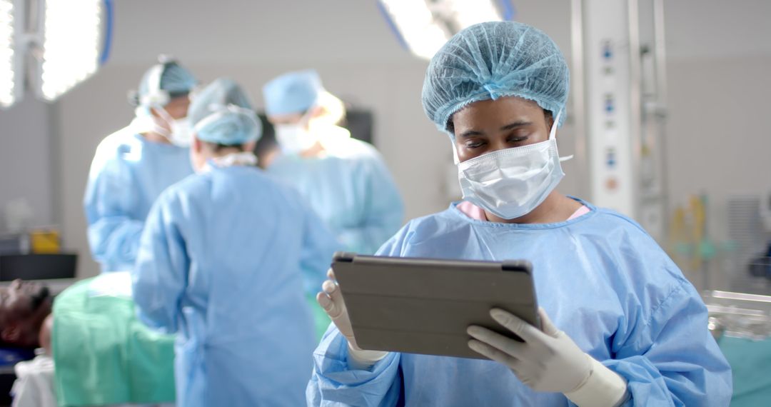 African American Female Doctor Using Digital Tablet in Operating Room - Free Images, Stock Photos and Pictures on Pikwizard.com