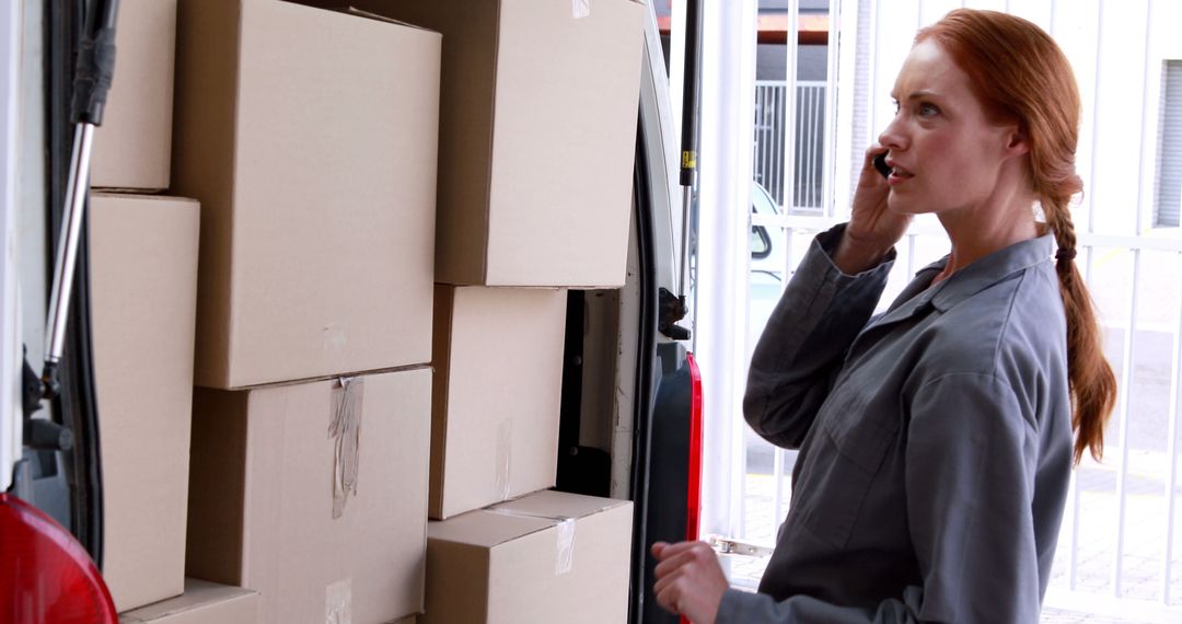 Delivery woman speaking on mobile phone while organizing packages in van - Free Images, Stock Photos and Pictures on Pikwizard.com