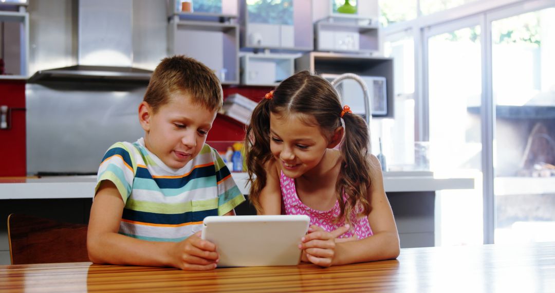 Smiling Children Using Tablet in Bright Kitchen - Free Images, Stock Photos and Pictures on Pikwizard.com