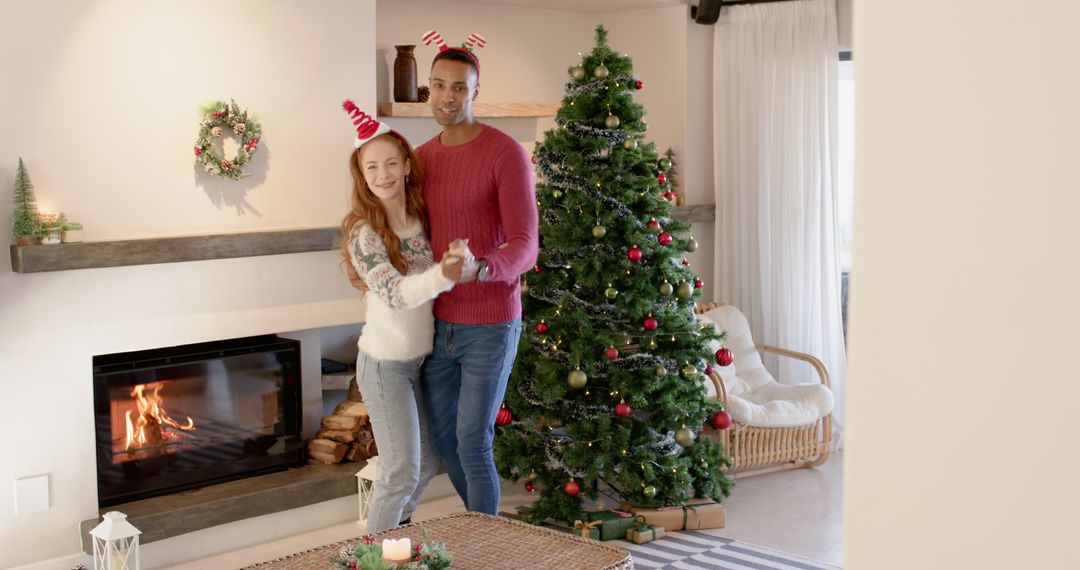 Joyful Couple Dancing Near Christmas Tree and Fireplace