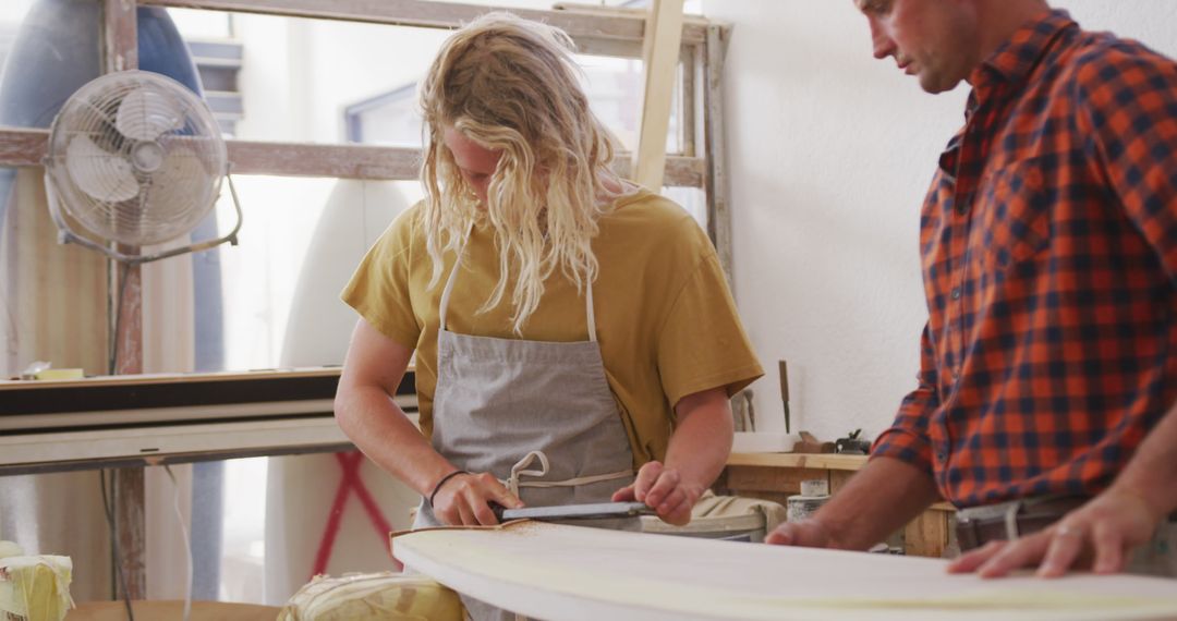 Two Craftsmen Working on Surfboard in Workshop - Free Images, Stock Photos and Pictures on Pikwizard.com