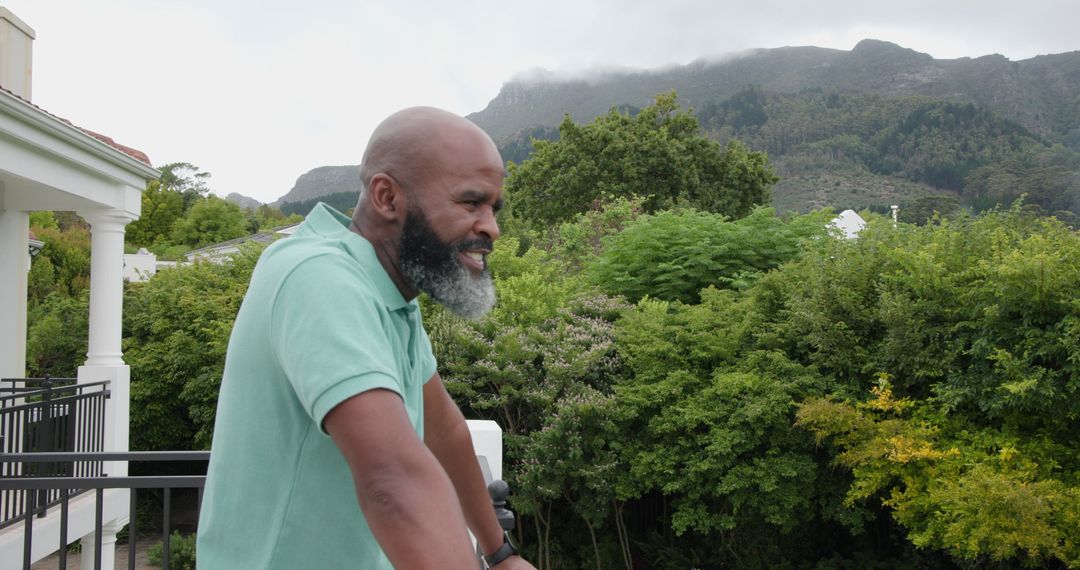 Man Enjoying Scenic Mountain View from Balcony