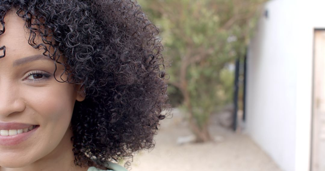 Confident Woman Smiling Outdoors with Modern Architecture Background
