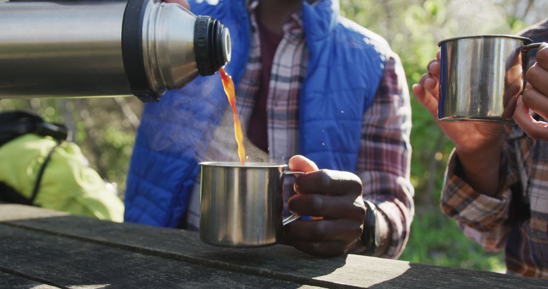 Pouring Hot Drink from Thermos During Outdoor Adventure - Free Images, Stock Photos and Pictures on Pikwizard.com