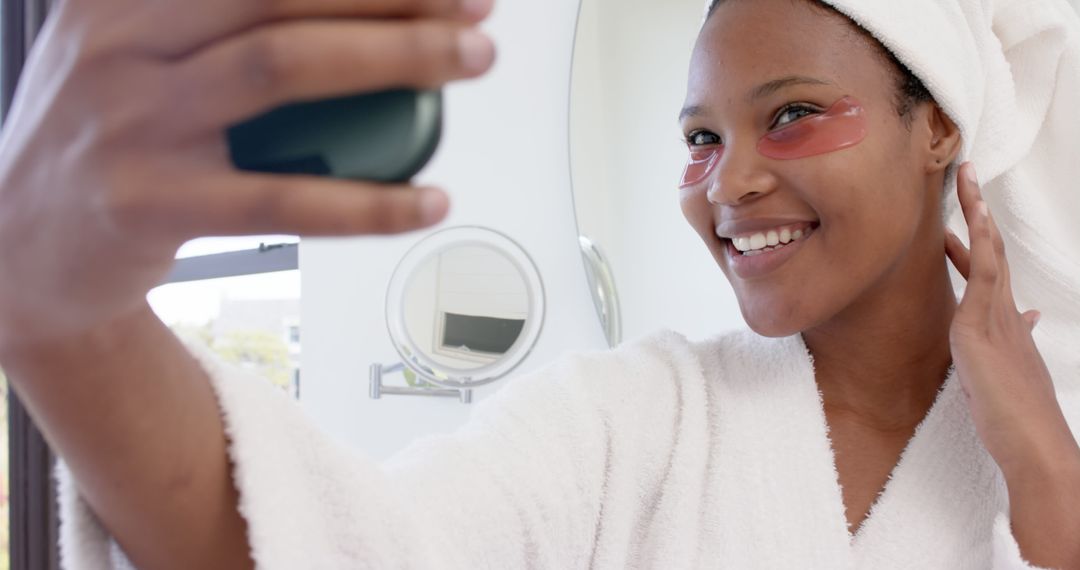 Smiling Woman Taking Selfie in Bathrobe with Eye Masks - Free Images, Stock Photos and Pictures on Pikwizard.com