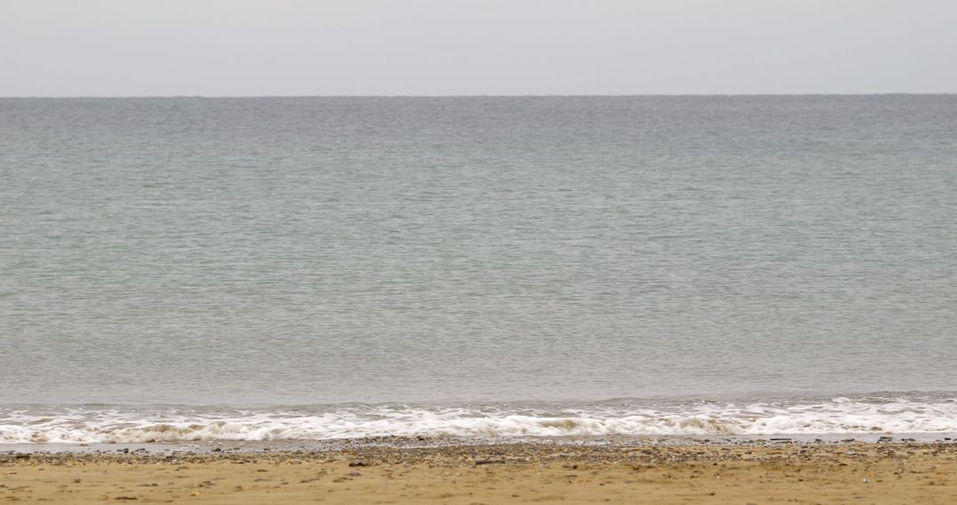 Peaceful Sea with Gentle Waves and Sandy Beach - Free Images, Stock Photos and Pictures on Pikwizard.com