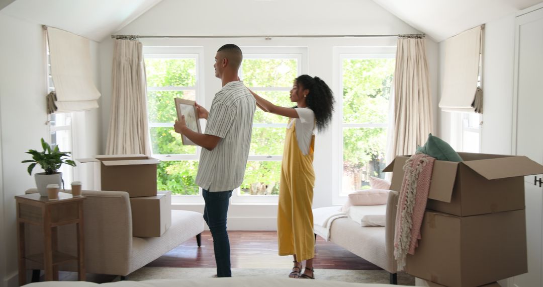 Couple Unpacking and Decorating New Home Living Room Together