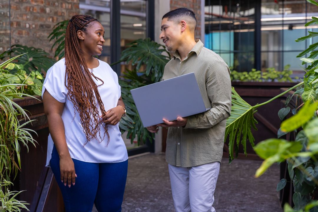 Diverse Professionals Discussing Project Near Greenery in Modern Office
