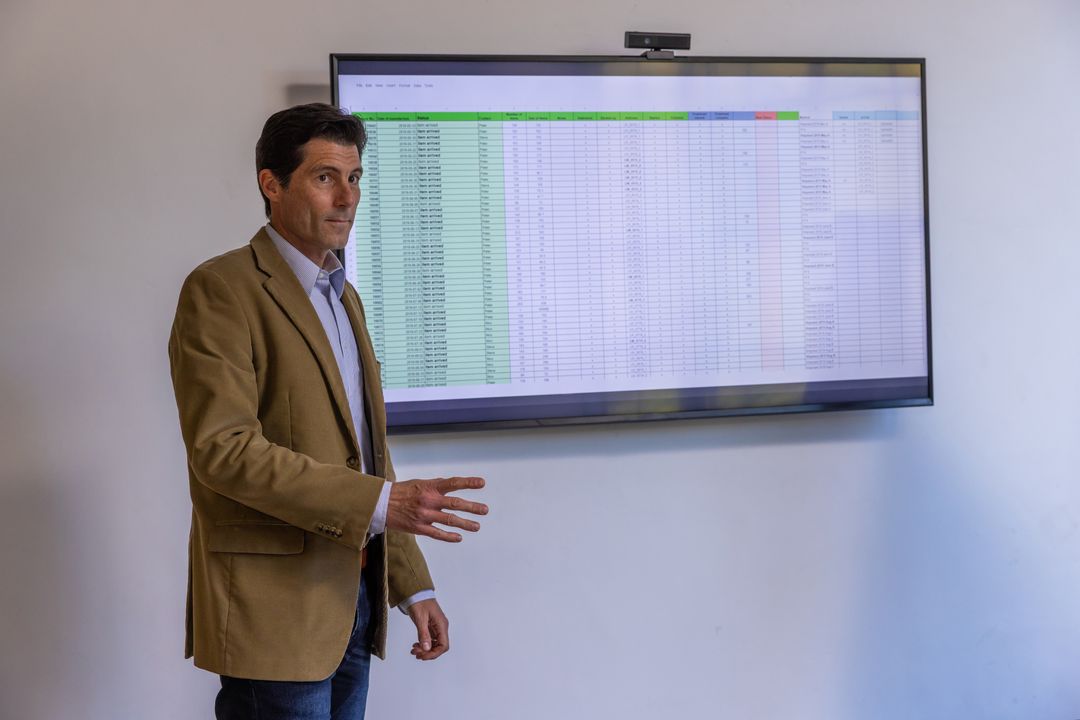 Businessman Presenting Spreadsheet Analysis in Modern Office