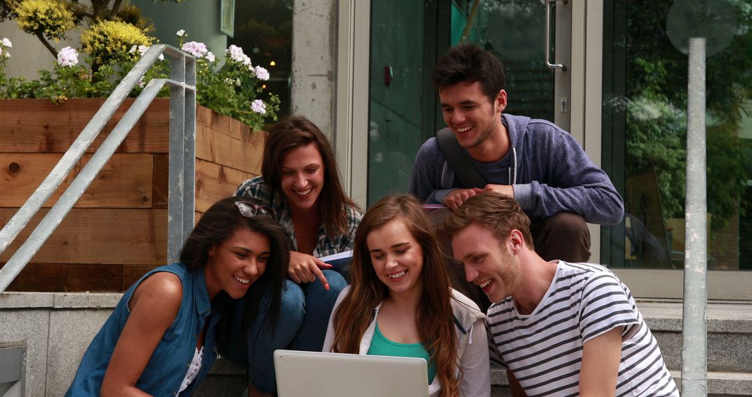 Group of Happy Friends Watching Laptop Outdoors - Free Images, Stock Photos and Pictures on Pikwizard.com