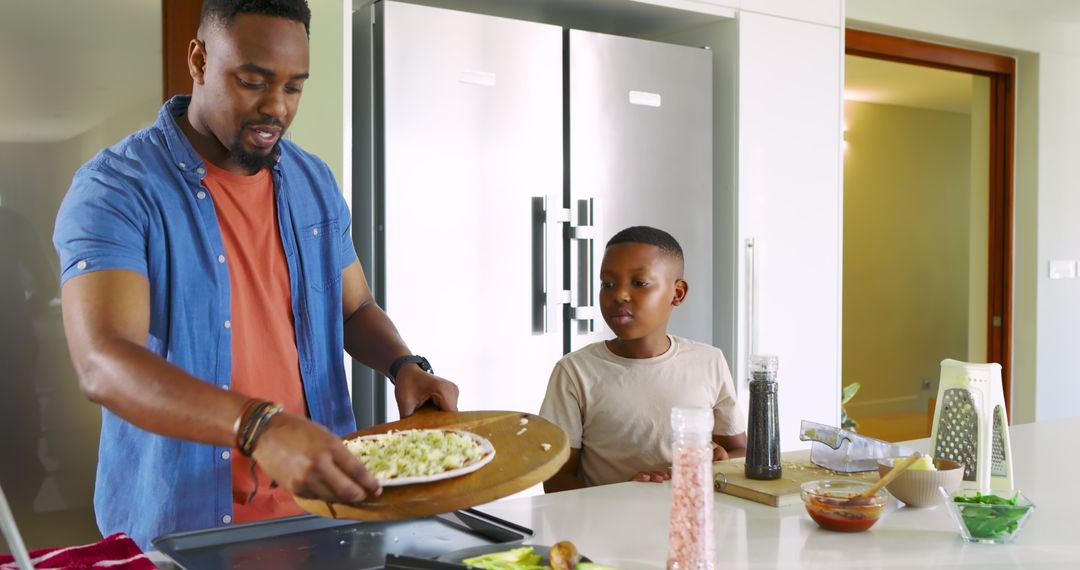 Father and Son Making Pizza Together in Modern Kitchen
