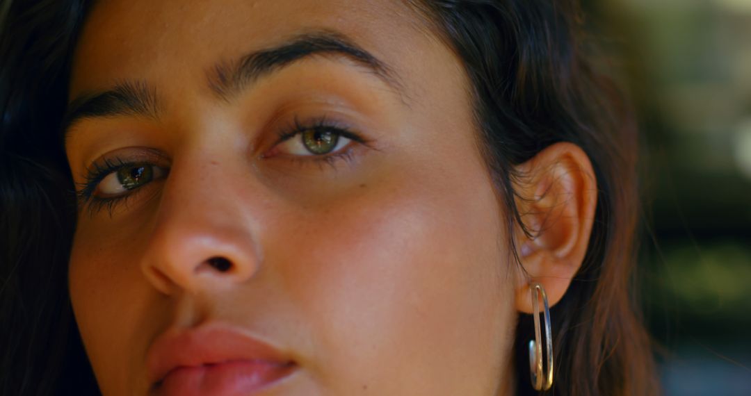 Close-Up of a Woman's Face with Natural Makeup and Hoop Earrings - Free Images, Stock Photos and Pictures on Pikwizard.com